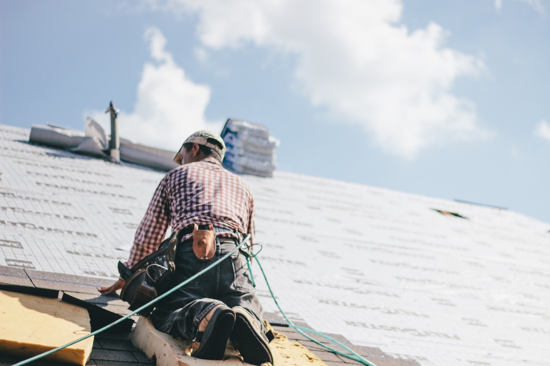 A roofer installing shingles