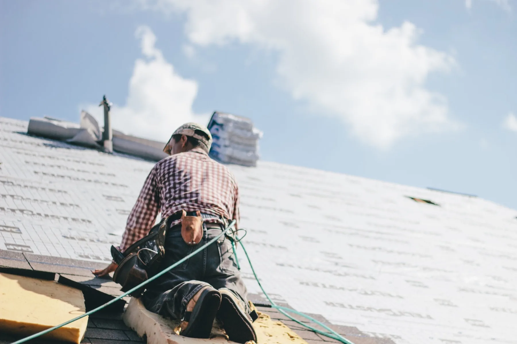 A roofer installing shingles